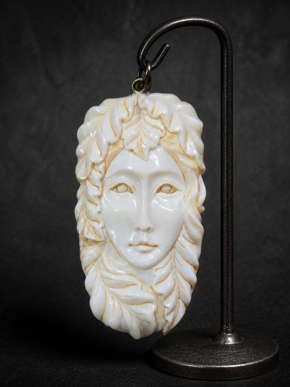 This piece is a hand-carved bovine (cow or water buffalo) bone pendant.